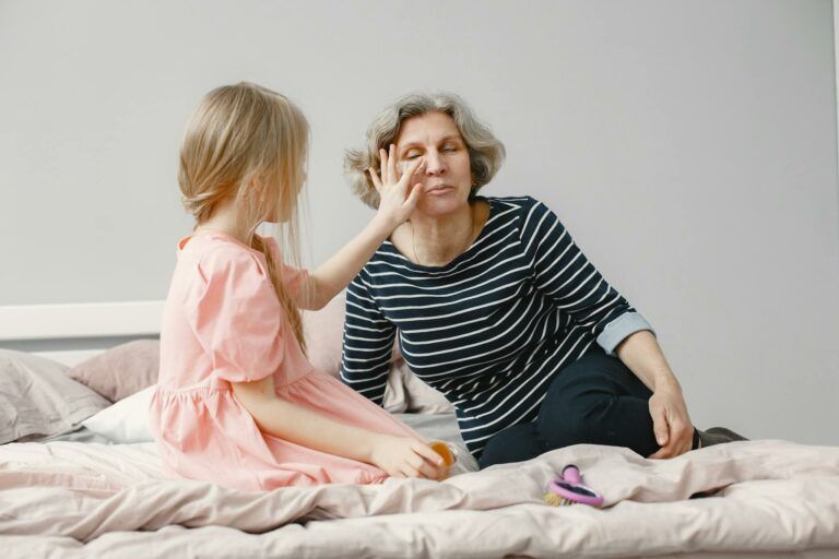 A touching moment of a grandmother and granddaughter bonding on a bed, highlighting family love.