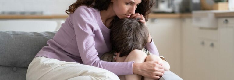 Parent consolant un jeune enfant assis sur ses genoux, soutien lors d'un deuil